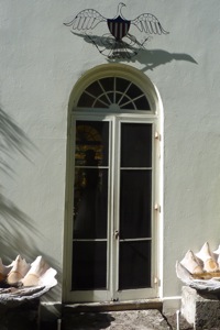 A door in a Florida with a wire American Eagle above the sunrise hemisphere window transom